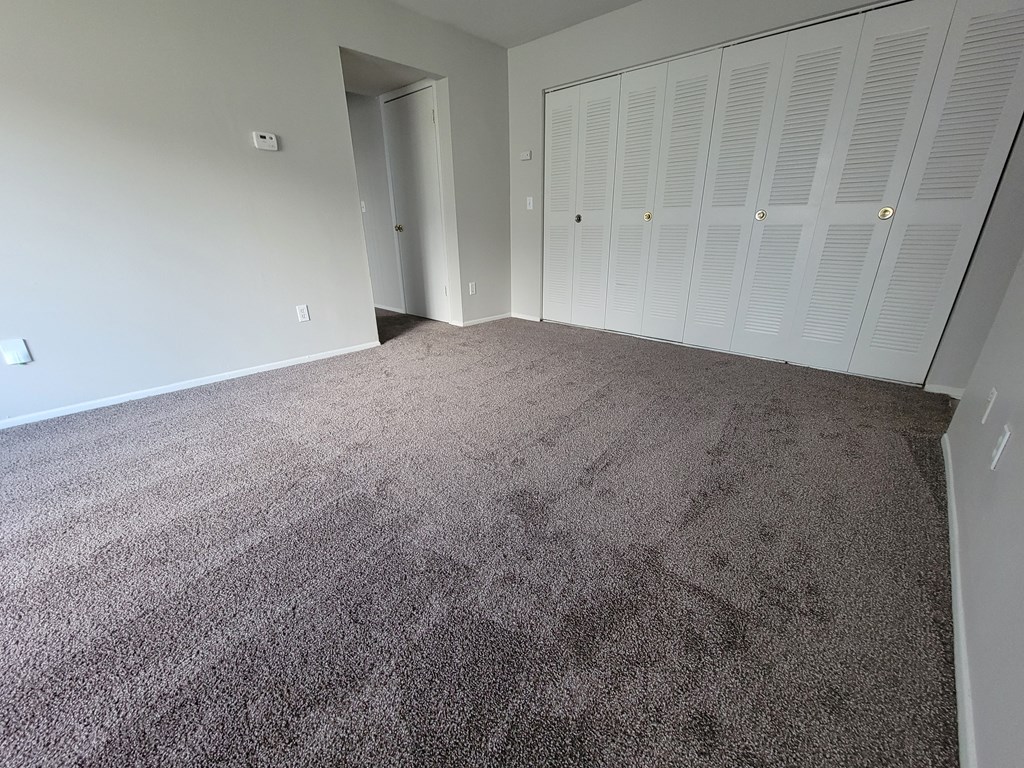Spacious living room with large coat closets at Garfield Commons Apartments in Clinton Township, Michigan