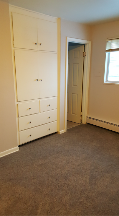 a bedroom with a dresser and a door and a closet