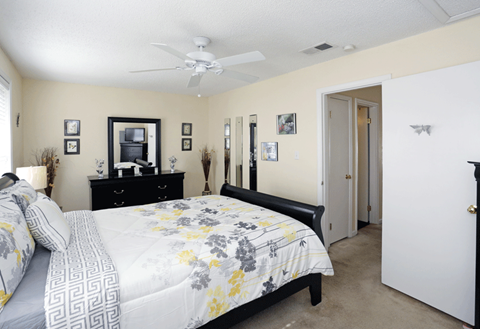 a bedroom with a large bed and a ceiling fan