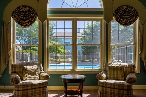 a living room with chairs and a view of a swimming pool