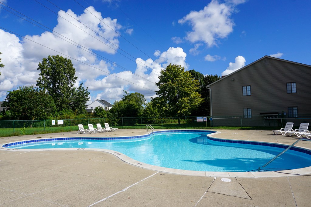 Swimming Pool and pool chairs with apartment in background, at Garfield Commons