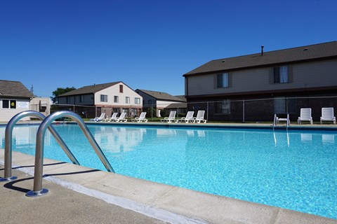 Outdoor swimming pool with sundeck at Farmbrooke Manor Apartments in Clinton Township MI