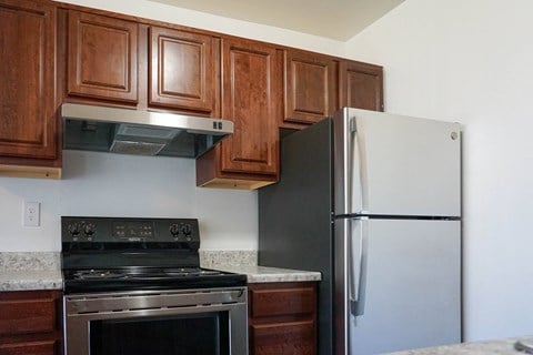 a kitchen with wooden cabinets and stainless steel appliances and a refrigerator