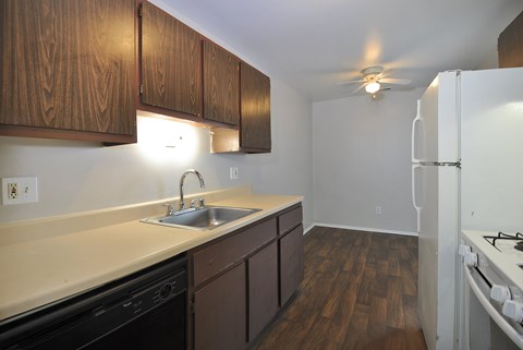 A kitchen with brown cabinets and a white fridge.
