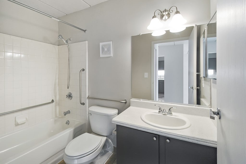 A white toilet sits next to a white sink in a bathroom.