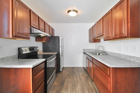 A kitchen with wooden cabinets and a black refrigerator.