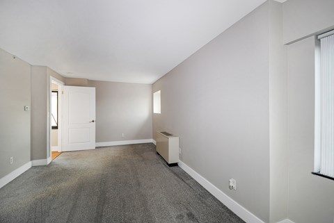 A room with a carpeted floor and a white door.