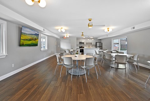 Resident clubhouse with comfortable seating, community tables, and bright natural light at Warren Woods Apartments in Warren, MI.