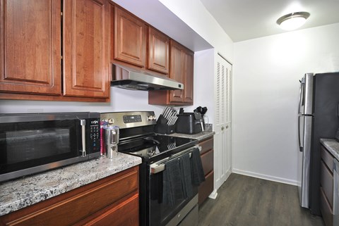 A kitchen with wooden cabinets and black appliances.