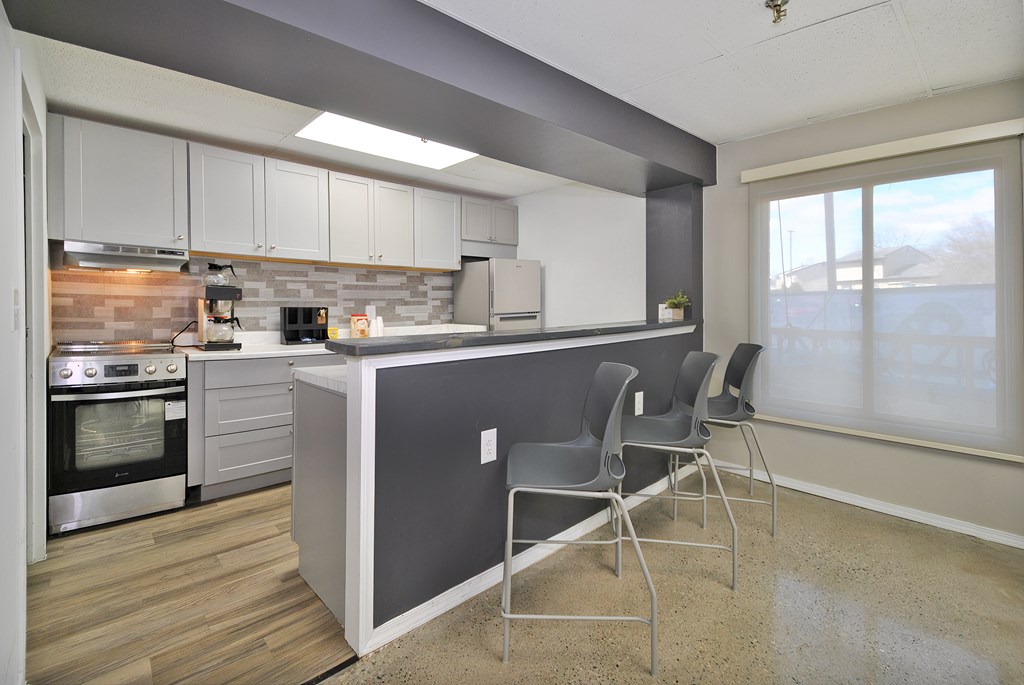 A kitchen with a grey island and white cabinets.