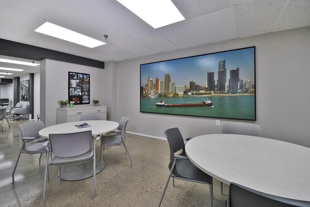 A conference room with a large screen displaying a city skyline.