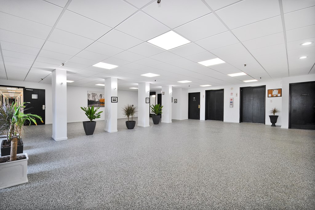A spacious office lobby with a grey floor and white walls.