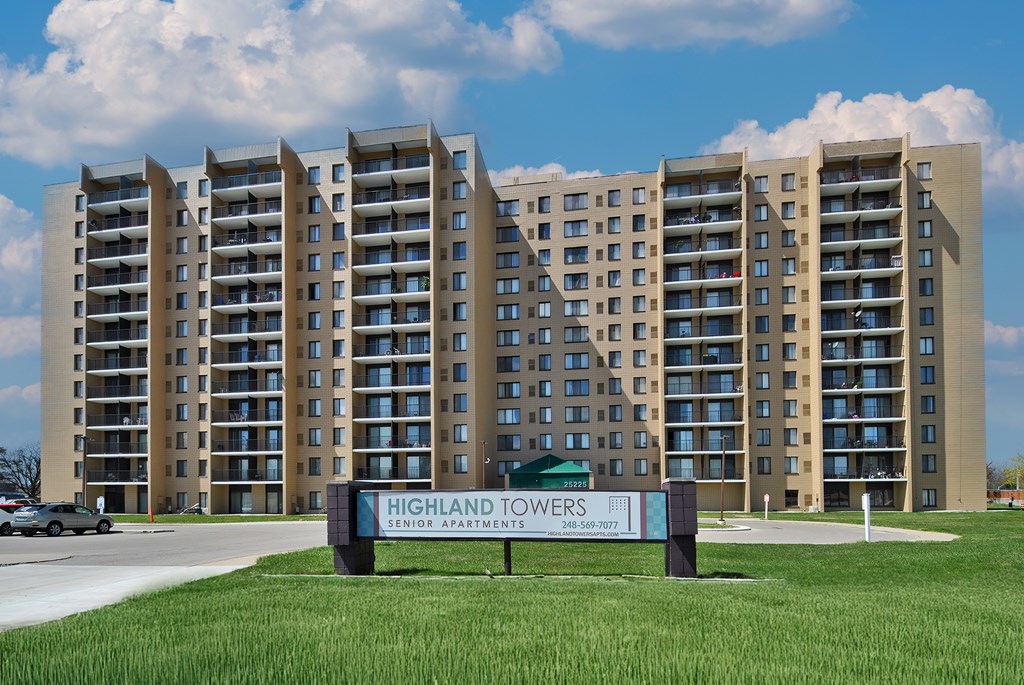 The Highland Towers senior apartment complex is a large building with a sign in front of it.