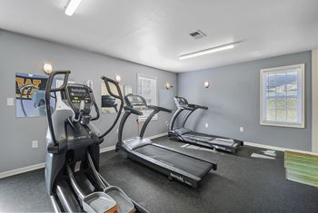 A gym with treadmills and elliptical machines.