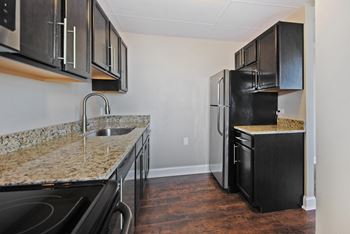 a kitchen with black appliances and granite counter tops and a black refrigerator