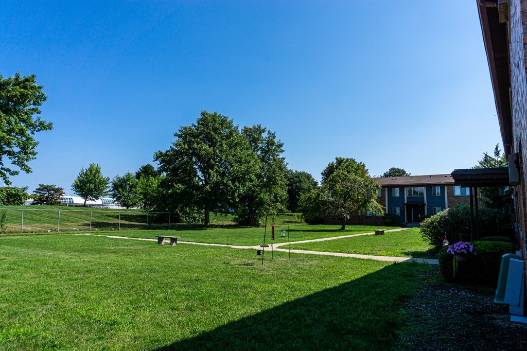 Large courtyard with sidewalks and benches at Golf Manor Apartments in Roseville, Michigan