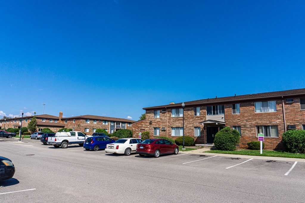 Exterior of apartment and ample parking space at Golf Manor Apartments in Roseville, Michigan