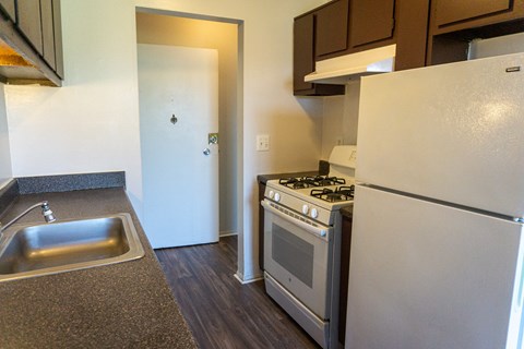 a kitchen with a stove and refrigerator and a sink
