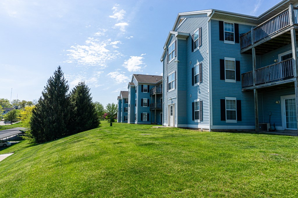 a large grassy area in front of an apartment building