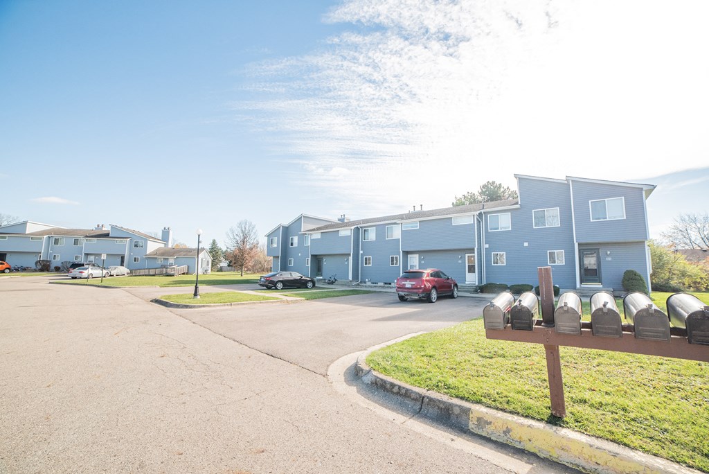 Building exteriors, parking spaces, and easy access mailing at Westwind Townhomes in Lansing, Michigan