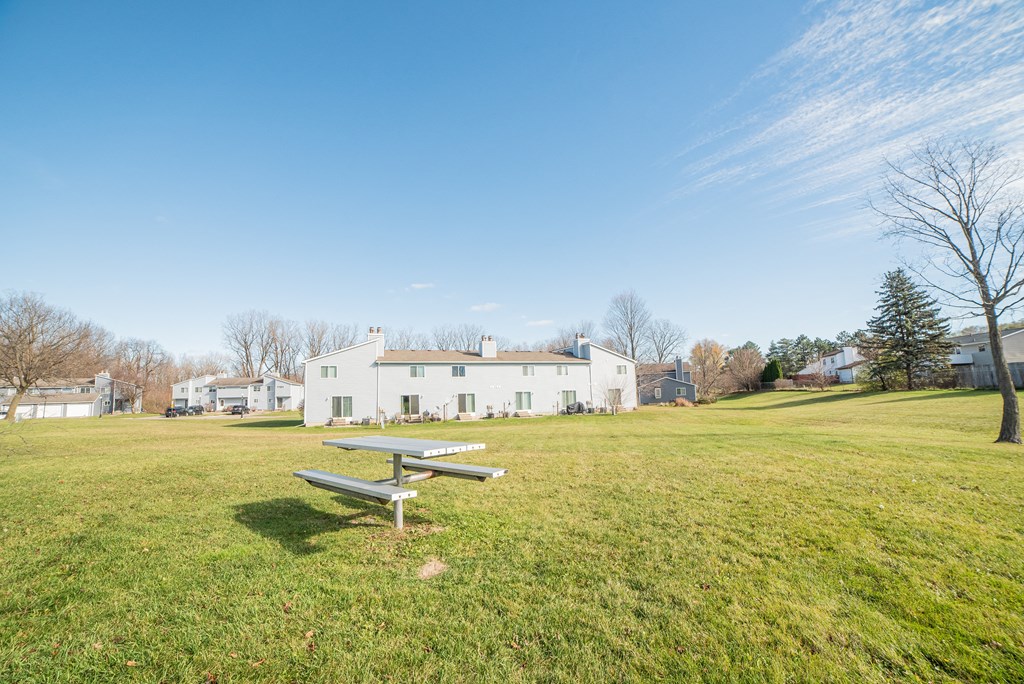 Large courtyard with picnic tables at Westwind Townhomes in Lansing, Michigan