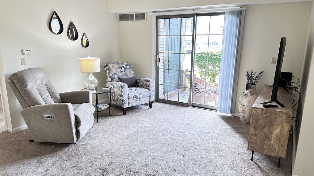 a living room with two chairs and a sliding glass door