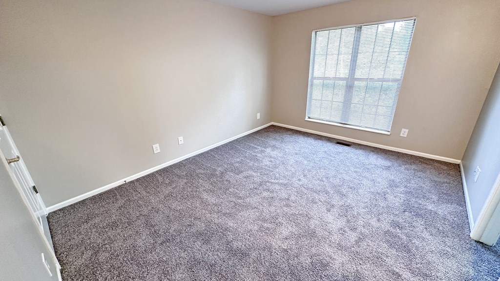 an empty room with carpet and a window