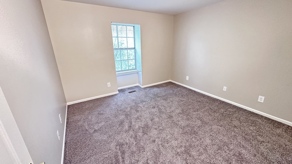 an empty room with carpet and a window