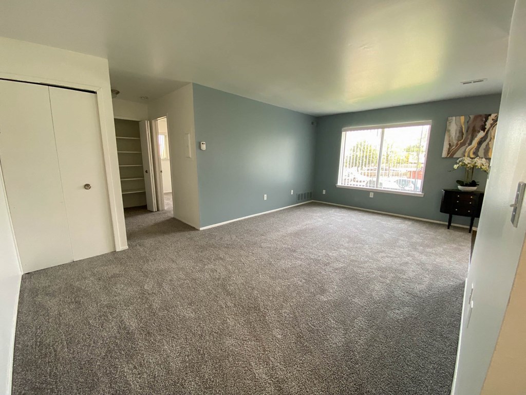 Spacious living room with window and hallway to other rooms, at Gale Gardens Apartments