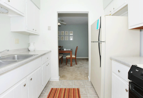 a kitchen and dining room with white cabinets and a white refrigerator