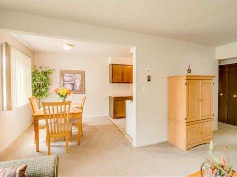 a living room and dining room with a table and chairs