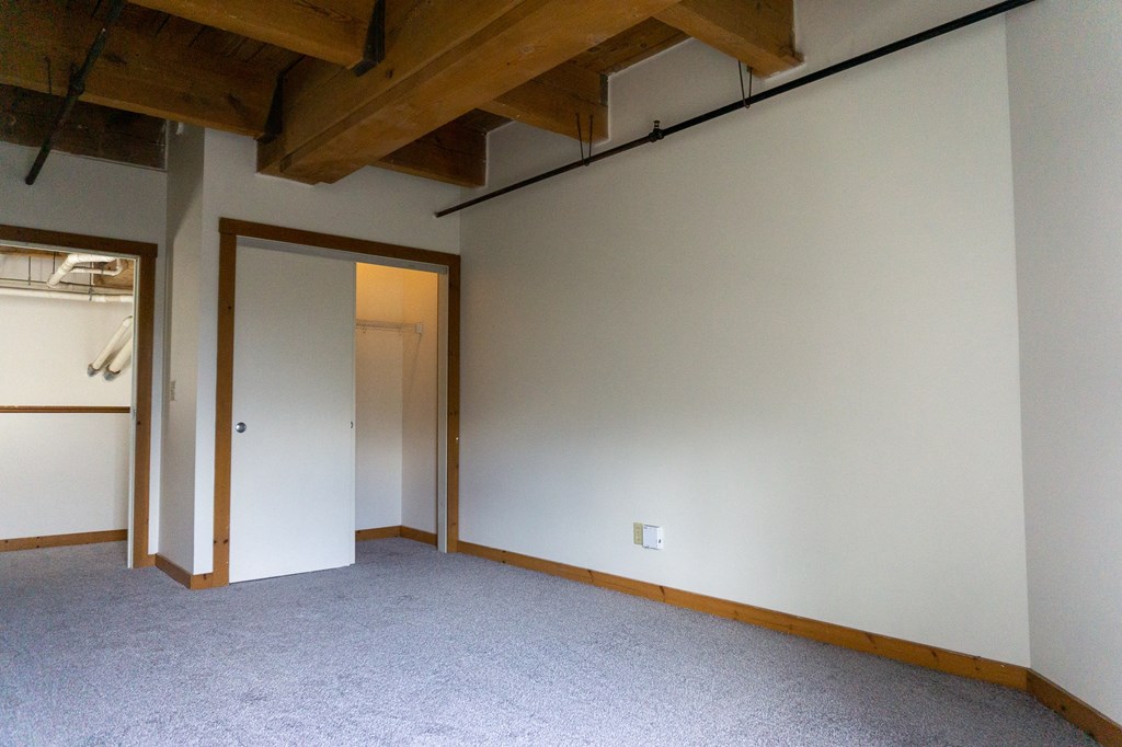 an empty room with white walls and a door to a closet