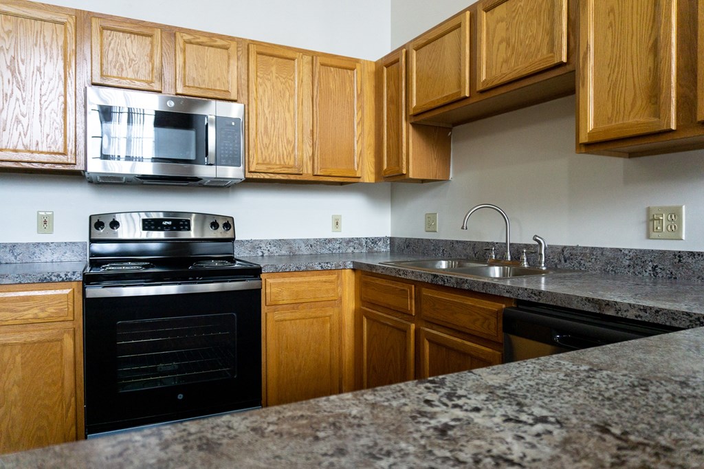 a kitchen with granite counter tops and wooden cabinets
