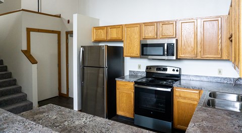 a kitchen with stainless steel appliances and wooden cabinets