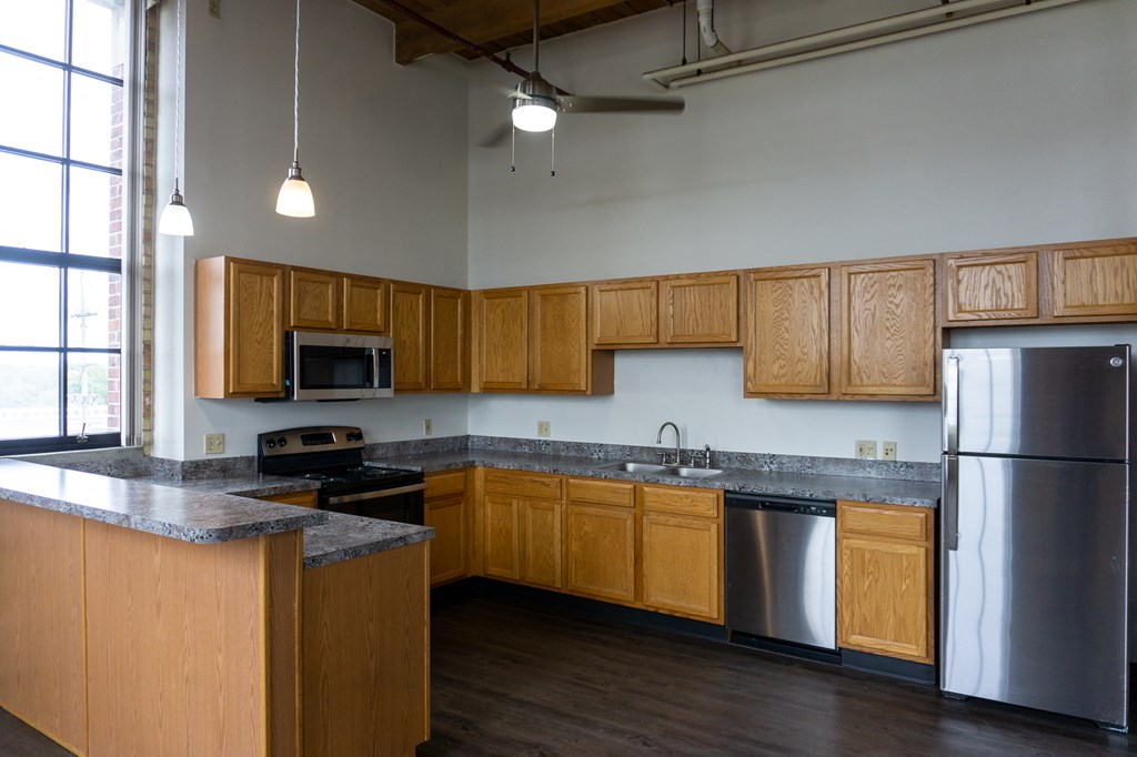 an empty kitchen with wooden cabinets and stainless steel appliances