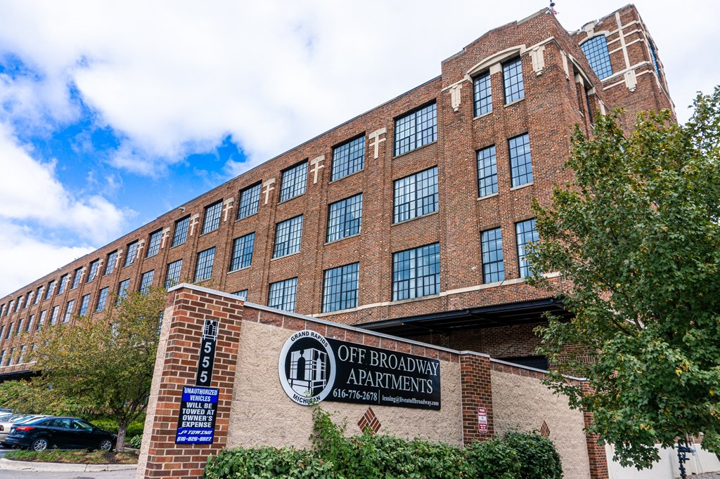 a large brick building with a sign that reads off broadway apartments
