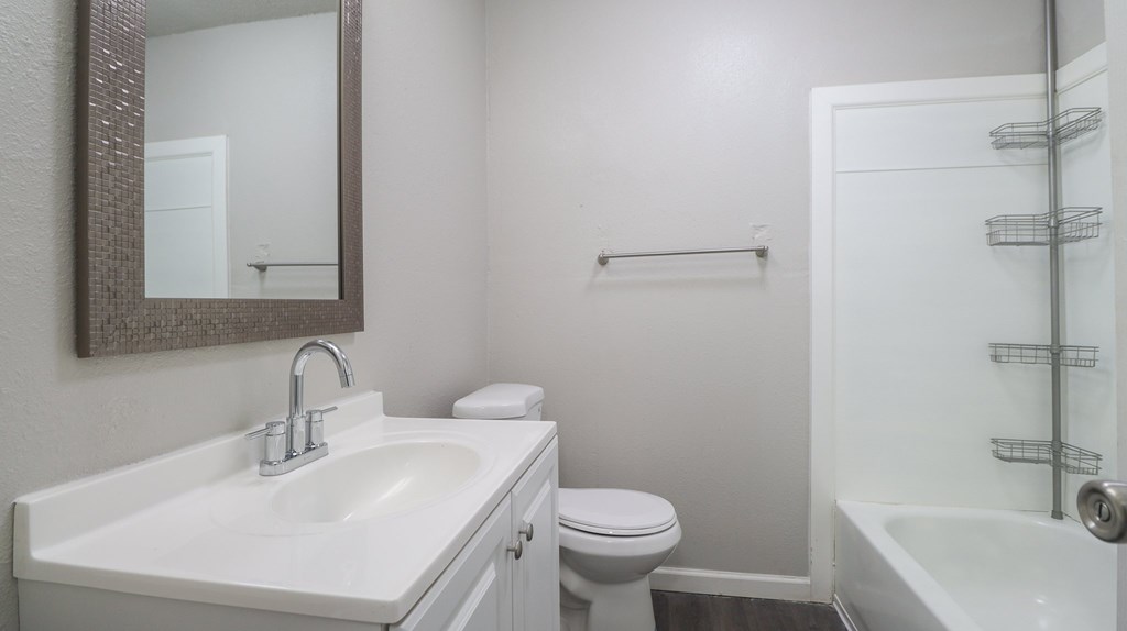 A white sink with a silver faucet and a mirror above it at hartford commons apartments in Pascagoula