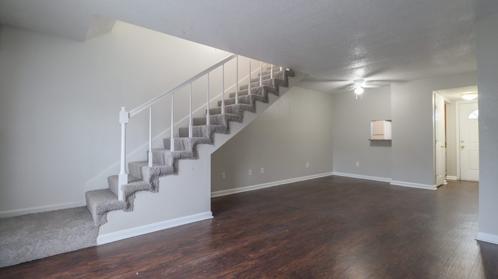 A staircase with a carpeted runner leads up to a second floor.