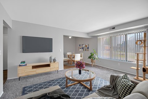 A living room with a flat screen TV mounted on the wall.