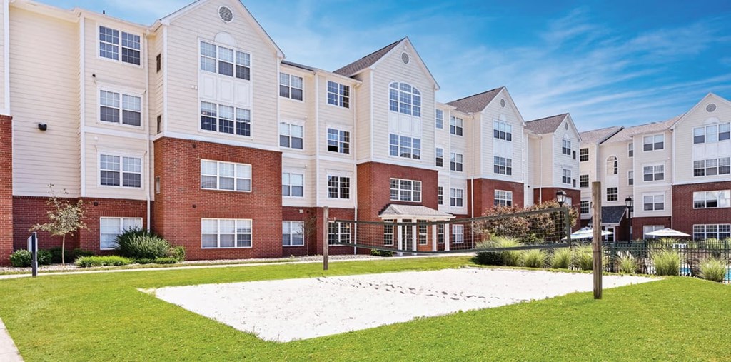 an exterior view of an apartment building with a yard