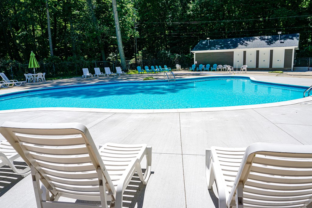 Swimming pool and pool chairs at Woodcrest Apartments in Westland, Michigan