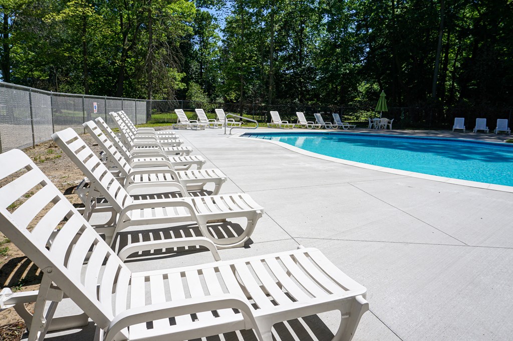 Swimming pool and pool chairs at Woodcrest Apartments in Westland, Michigan