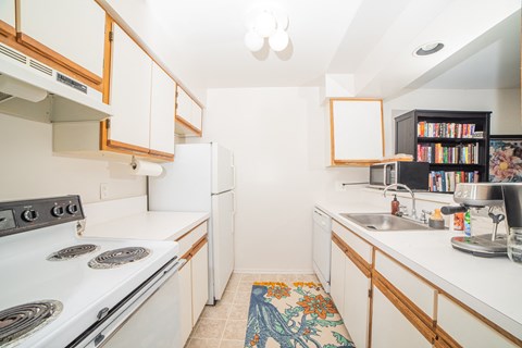 a kitchen with white appliances and wooden cabinets and a sink