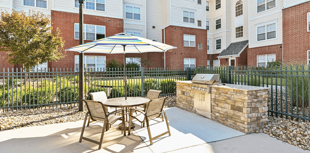 a patio with an umbrella and a table with chairs