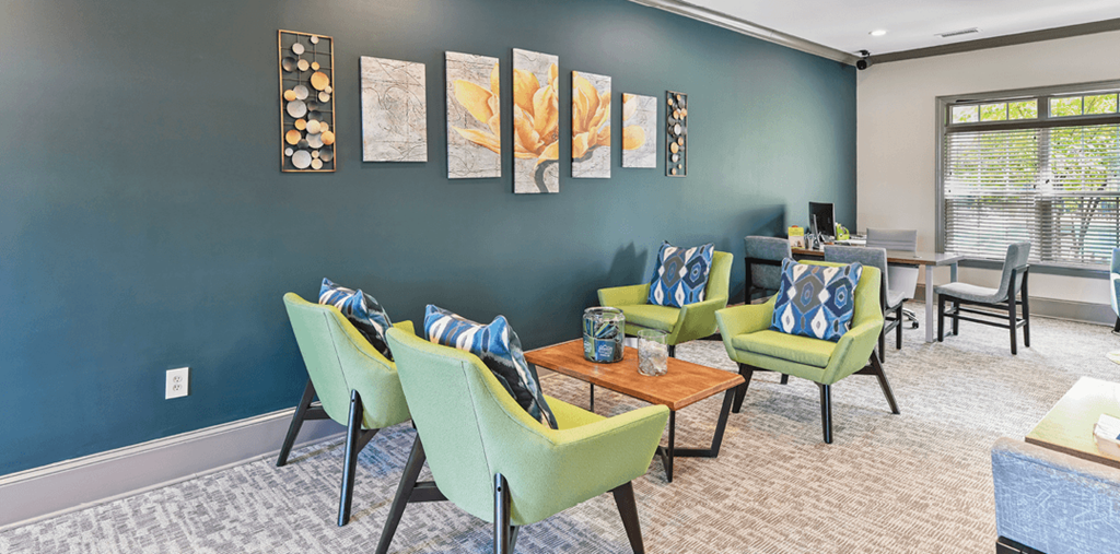 a living room with green chairs and a coffee table and a dining room with chairs