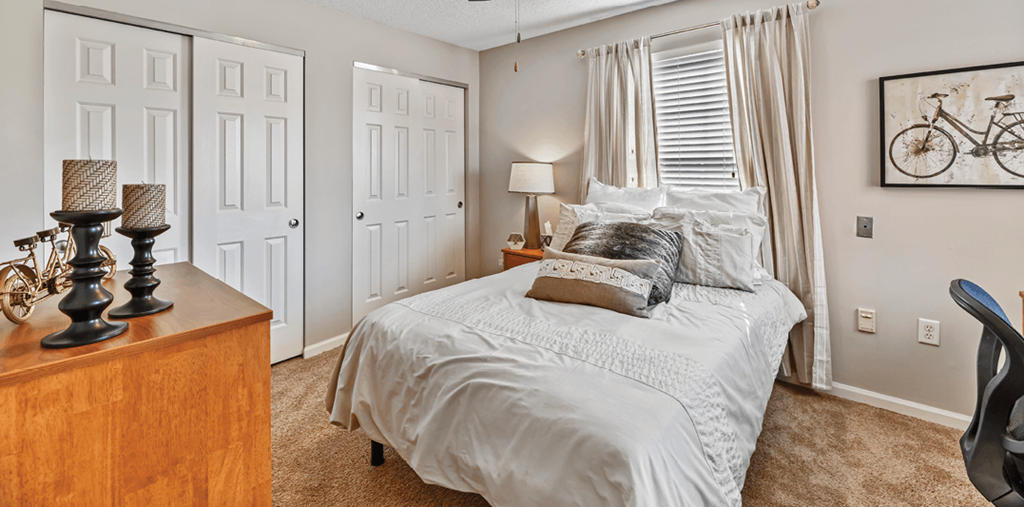 a bedroom with a bed and a dresser and a window