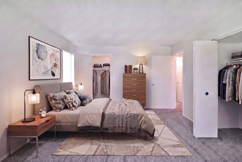 A bedroom with a bed, nightstand, and a painting on the wall.