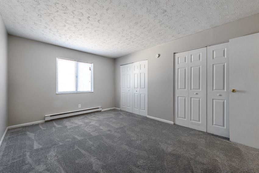 a large and spacious bedroom with two closets and a window at Timber Creek Apartments in Niles, Ohio