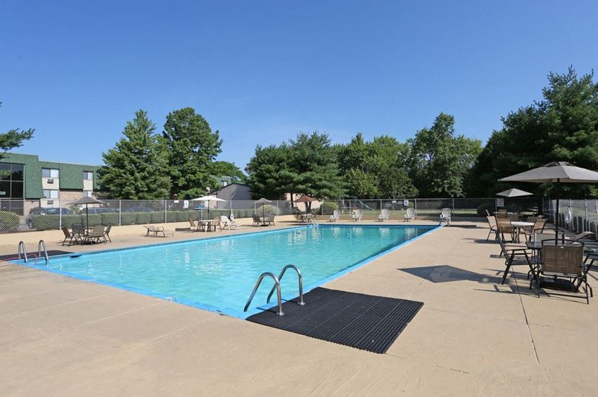 a sparkling swimming pool with chairs at Timber Creek Apartments in Niles, Ohio