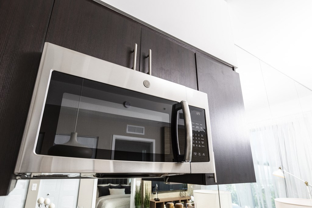 a microwave oven in a kitchen with black cabinets